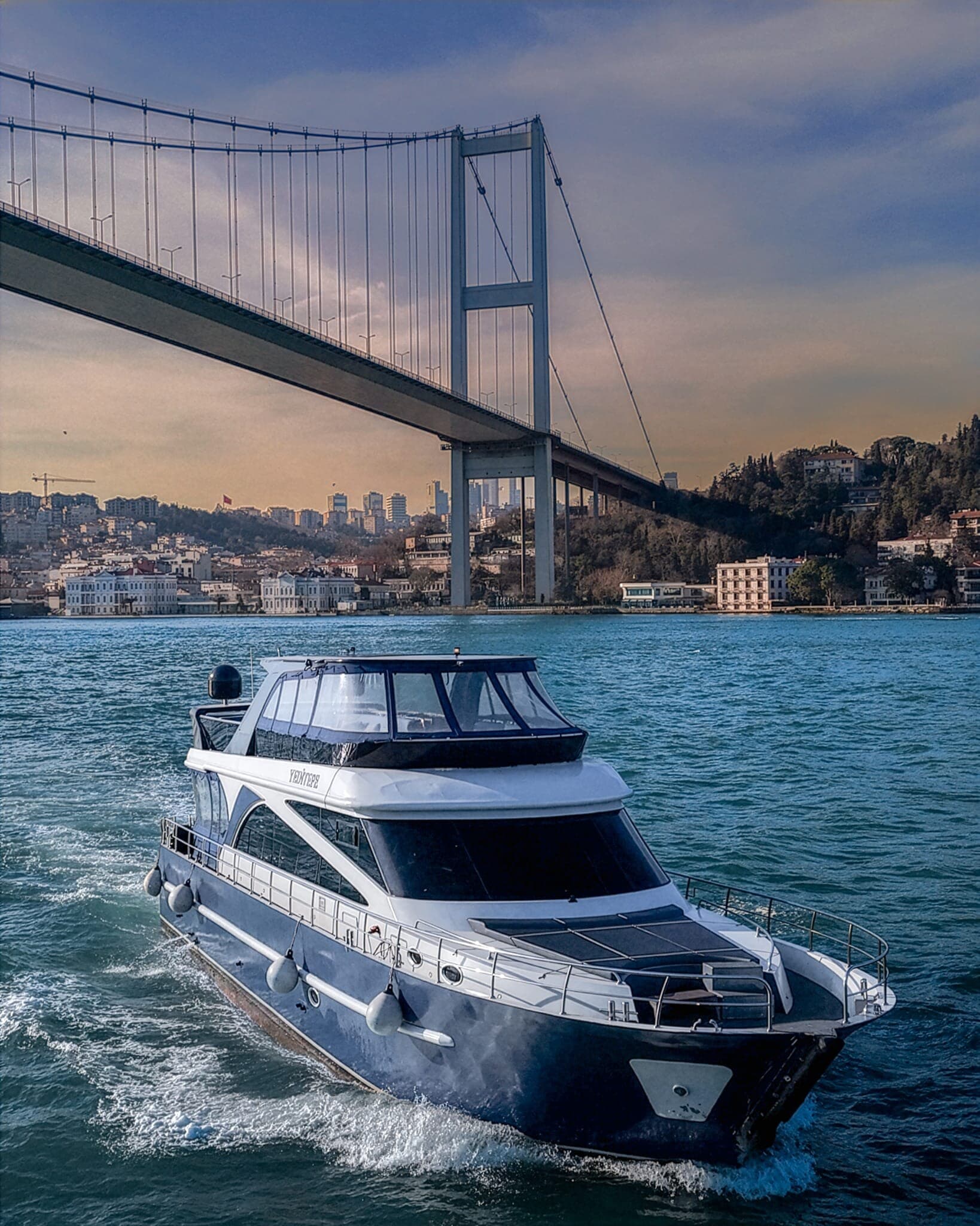 A private yacht cruising under the Bosphorus Bridge